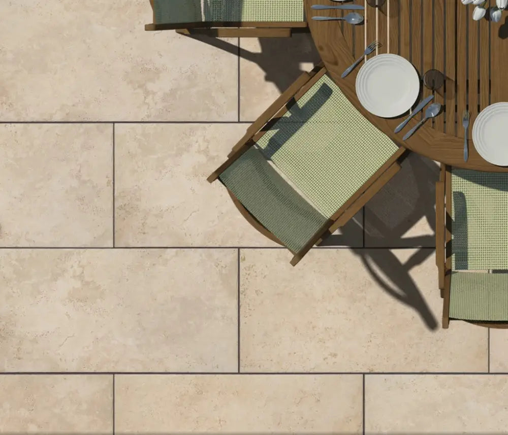 Aurum Travertine Outdoor Porcelain Paving Slabs in a garden with chairs and a table