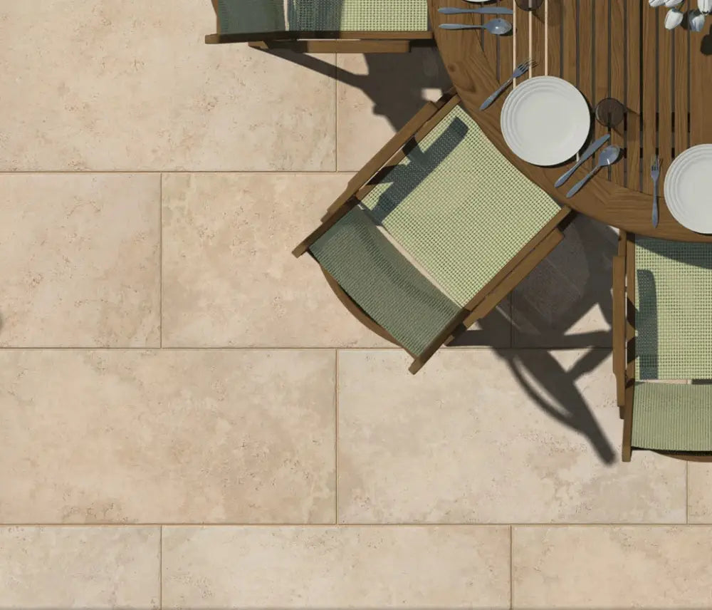 Aurum Travertine Outdoor Porcelain Paving Slabs in a garden with chairs and table. The slabs are connected with light joints