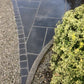 Black limestone cobbles between pavement slabs and stones.