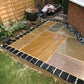 Slab patio outlined with black limestone cobbles.