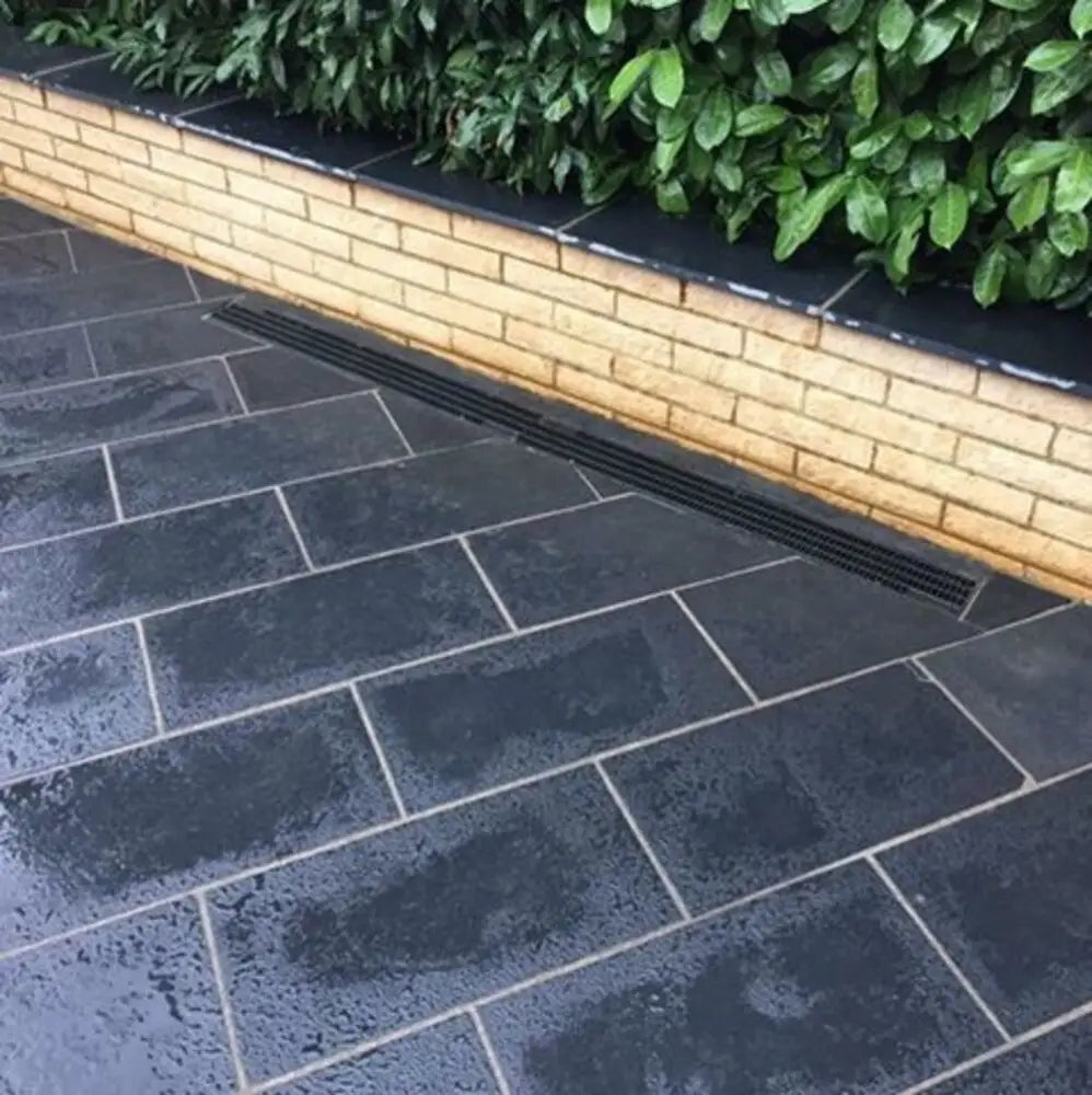  Outdoor area paved with black limestone slabs.