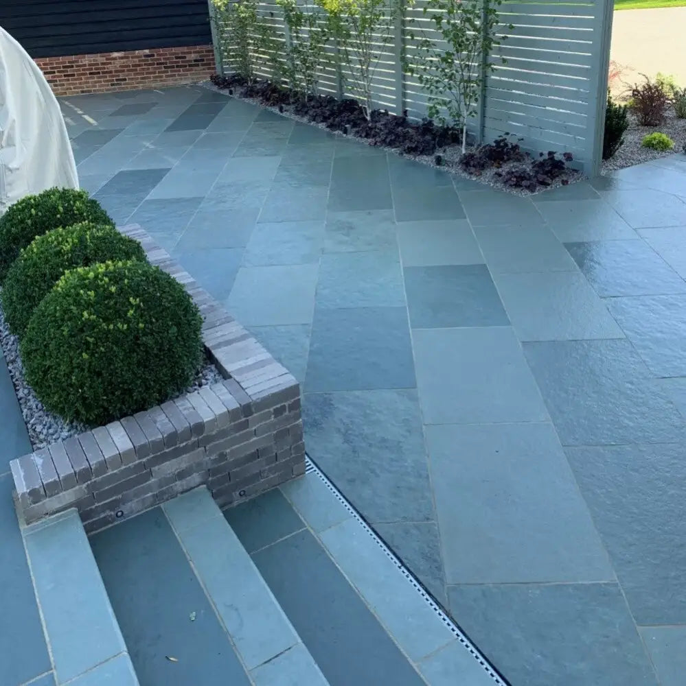 Blue limestone paving slabs forming diagonal pattern in garden flooring.