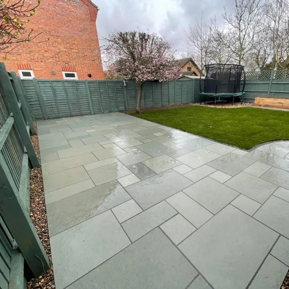 Blue limestone paving slabs paired with artificial grass in a garden